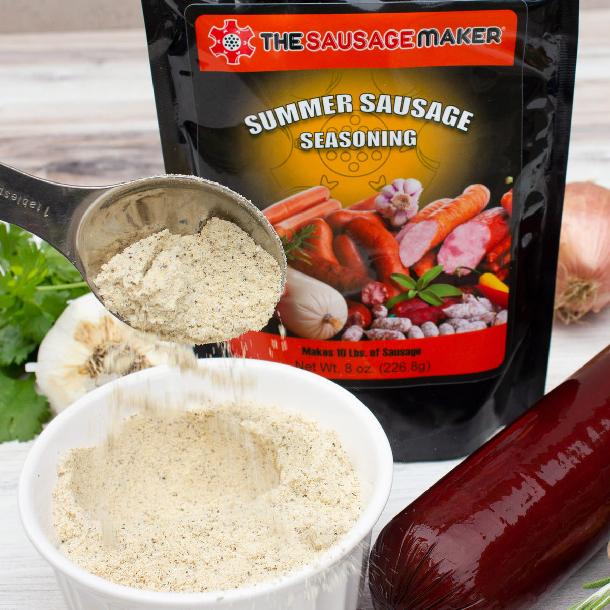 Summer sausage seasoning package with a scoop of seasoning and a summer sausage on a wooden surface.