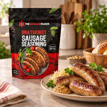A bag of The Sausage Maker Bratwurst Sausage Seasoning stands on a kitchen counter beside a plate of cooked bratwurst, sauerkraut, and mustard, with a blurred kitchen background.